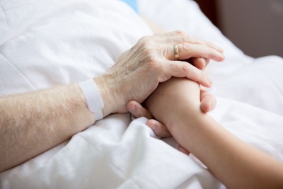 Patient holding hand with visitor